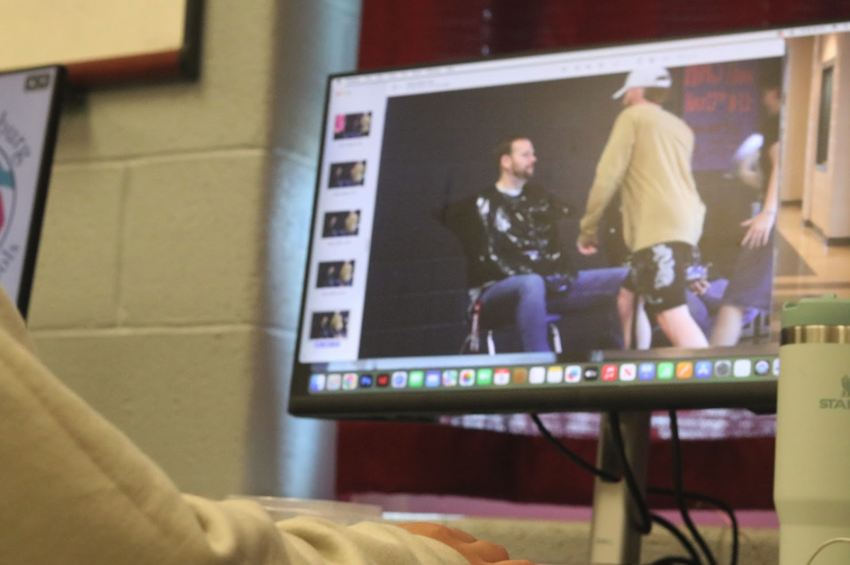 Newspaper student looks through the photos she took of the "Pie a teacher" fundraiser that happened earlier that day.